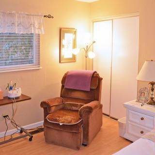 A cozy living room corner with an armchair, a lamp, and a small table.