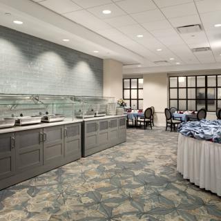 A spacious and elegantly designed buffet area with dining tables and chairs.