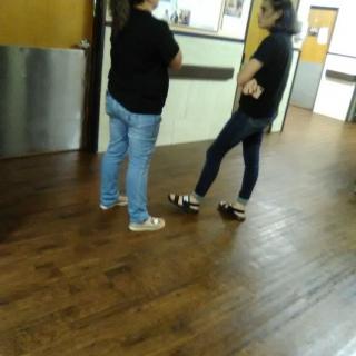 Two people standing and conversing in a hallway.