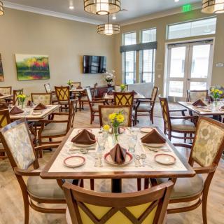 An elegantly decorated dining room with neatly arranged tables and chairs.