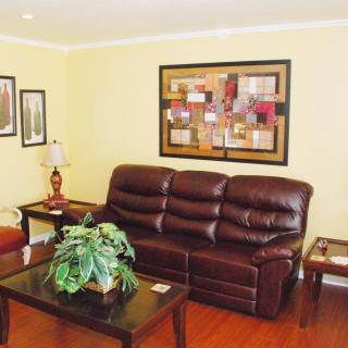 A cozy living room with a leather sofa, coffee table, and decorative artwork.