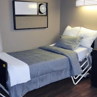 A neatly arranged hospital bed in a well-lit room, designed for comfort and care.