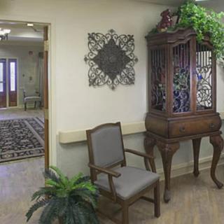 A room interior with a traditional wooden cabinet, a chair, and decorative elements.
