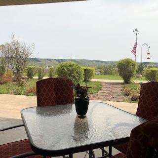 A tranquil patio view overlooking a landscaped garden and open landscape.