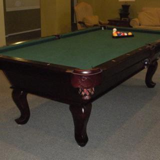 A well-maintained pool table set up for a game in a cozy room.