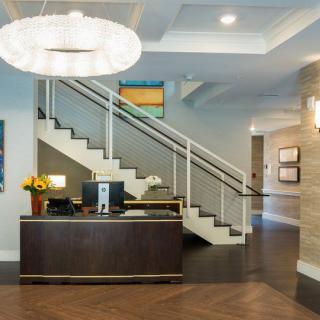 A modern office reception area with a staircase and elegant decor.