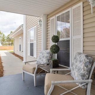 A cozy outdoor porch area with comfortable chairs and decorative plants.