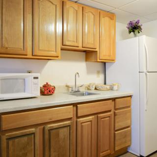 A small kitchen with wooden cabinets, a white refrigerator, and countertop appliances.