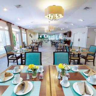 A spacious and elegantly decorated restaurant dining area with neatly arranged tables and chairs.
