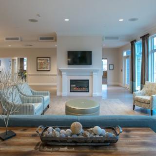 A spacious living room featuring modern furniture, a fireplace, and a television.