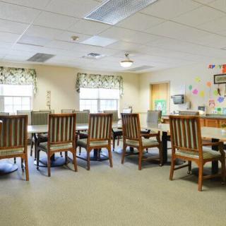 A spacious meeting room with a large conference table surrounded by chairs and decorated walls.
