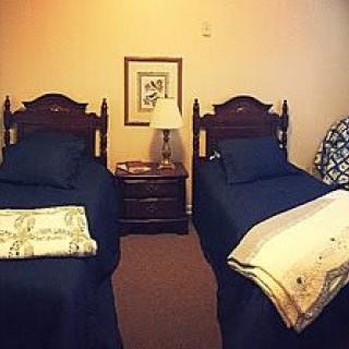 A cozy bedroom with twin beds and a shared nightstand.
