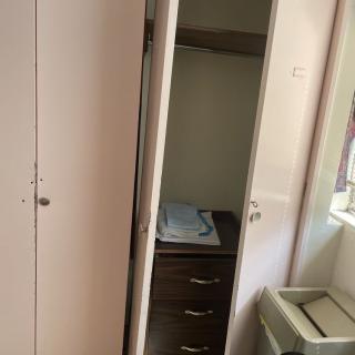 An open wardrobe revealing shelves and hanging space inside.
