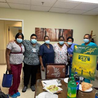 Healthcare team celebrating together in a hospital setting.