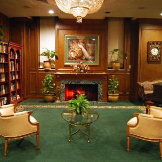 A luxurious lounge with a fireplace, elegant furniture, and a chandelier.