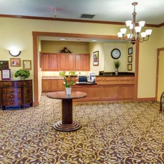 A well-appointed reception area with a central desk, decorative lighting, and elegant furnishings.