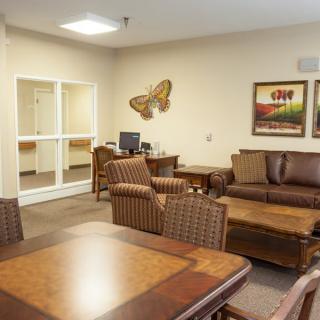 A cozy lobby area with comfortable seating, tables, and decorative artwork on the walls.