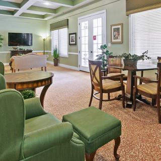 A cozy living room with green furniture and ample natural light.