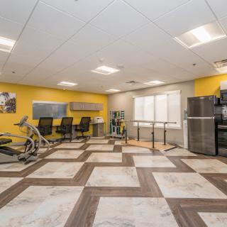 A spacious gym with modern exercise equipment and a bright, inviting atmosphere.