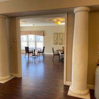 A view of a spacious dining area featuring elegant columns and ample natural light.