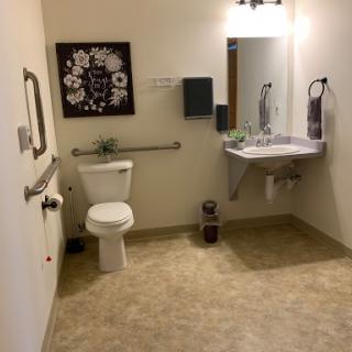 A view of a clean and accessible bathroom with a toilet and sink.