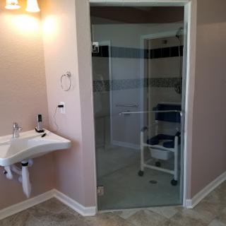 A modern bathroom featuring a glass door shower and accessible design elements.