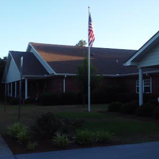 A peaceful residential building with an American flag displayed in the front yard.