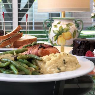A delicious meal featuring salmon, green beans, mashed potatoes, a sandwich, and chocolate cake with raspberries.