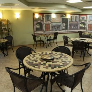 Cozy cafe interior with round tables and a mural on the wall.
