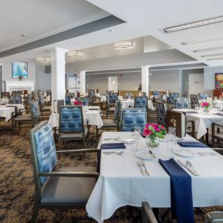 An elegant dining area with neatly arranged tables and chairs, set for a meal.