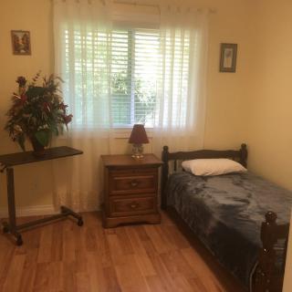 A small, cozy bedroom with a single bed and a window letting in natural light.