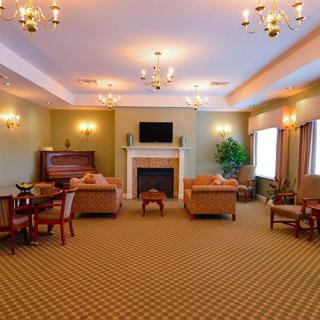 An elegant living room with sofas, a fireplace, and chandeliers.