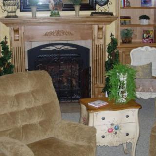 A cozy living room with a fireplace, comfortable seating, and decorative furniture.