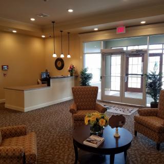 A cozy lobby with a seating area, reception desk, and decorative lighting.
