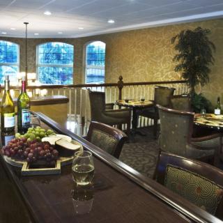 An elegant dining area with a set table, featuring wine and grapes as part of the decor.