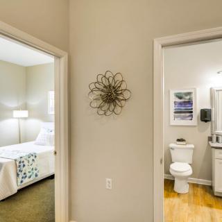 A view of a hallway leading to a bedroom on the left and a bathroom on the right, showcasing a modern interior design.