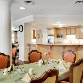 A well-furnished dining area with a set table and an adjoining kitchen.