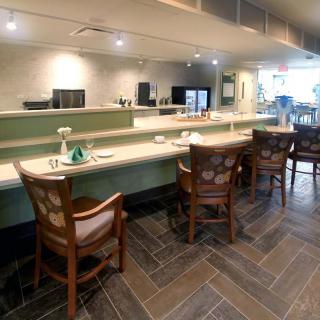 A modern cafe interior featuring a counter with several chairs.