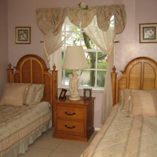 A cozy bedroom with twin beds and a shared nightstand between them.