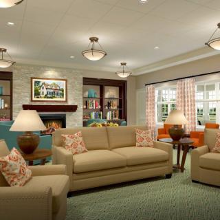 A cozy and well-decorated living room with sofas, a fireplace, and elegant lighting.