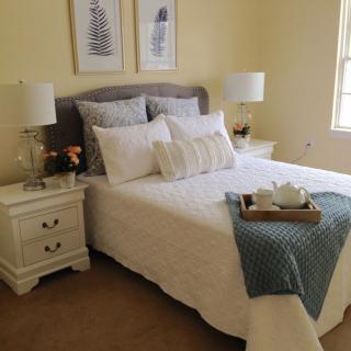 A cozy and stylish bedroom with neatly arranged bedding and elegant decor.