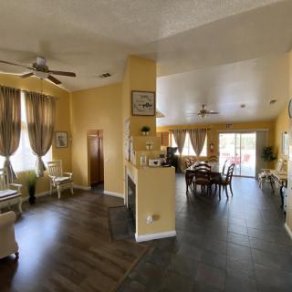 A spacious open floor plan living room and dining area with elegant decor, featuring wood flooring and abundant natural light.