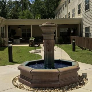A courtyard featuring a central fountain surrounded by a building.