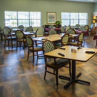 An empty dining room with neatly arranged tables and chairs.