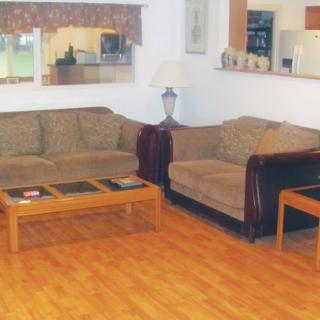 A cozy living room with two brown sofas and a wooden coffee table on laminate flooring.