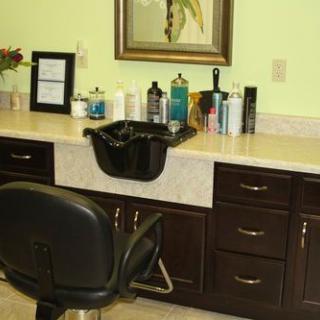 A hair salon setup with styling tools and a sink.