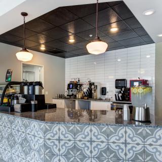 A modern coffee shop interior with a stylish counter and hanging lights.