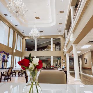 Luxurious interior with elegant chandeliers and a vase of roses on the table.