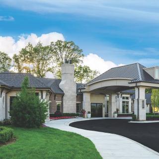 A modern building with a landscaped entrance and curved pathway.