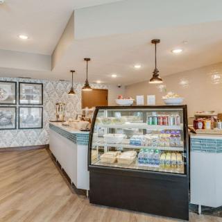 A cozy cafe interior featuring a food display counter with various items for sale.